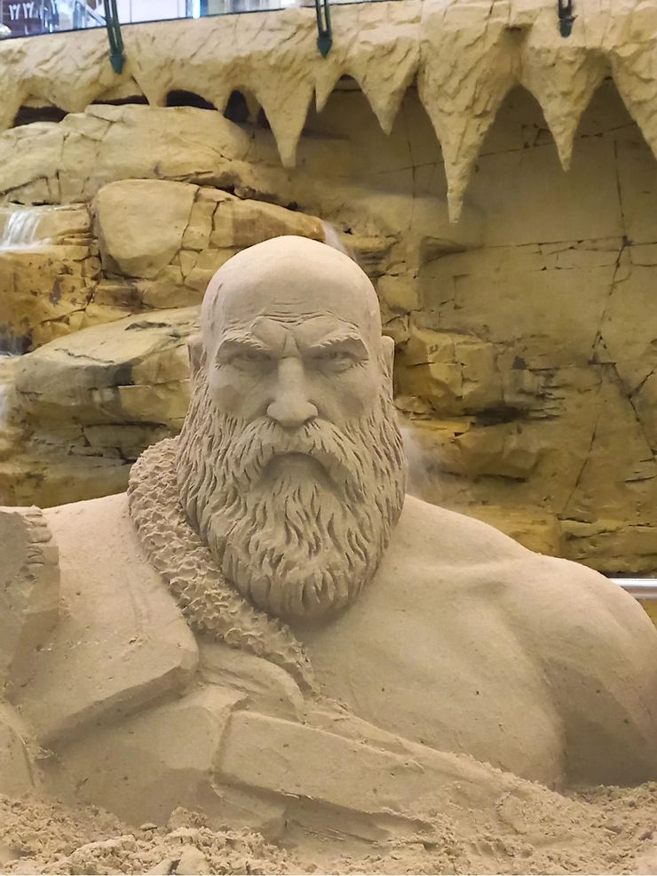Kratos from God of War is depicted as an impressive sand sculpture
